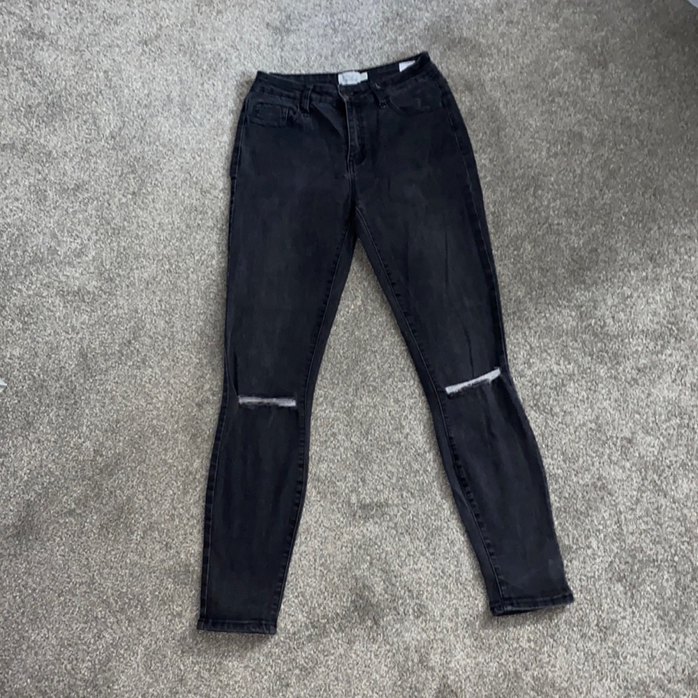 High rise, stretchy black jeans, with knee rips.